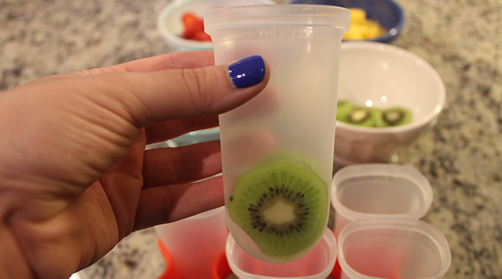 A hand holding a plastic cup
Description automatically generated