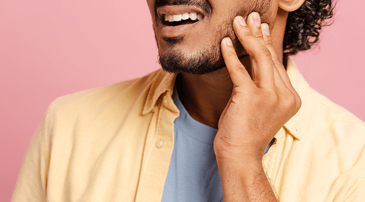 Person holding their jaw in pain.