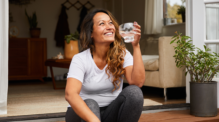 Person smiling and drinking water.