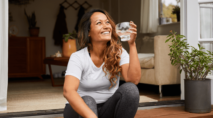 Person smiling and drinking water.