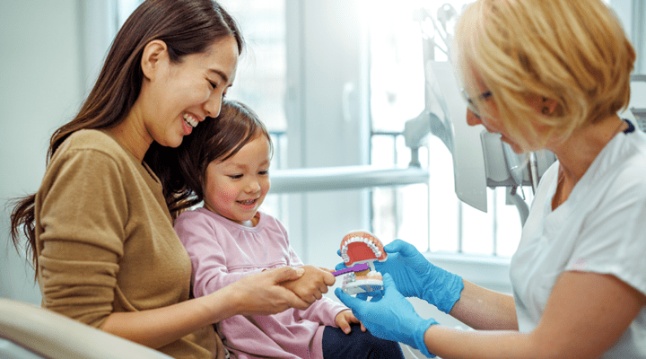 Mother and child talking to a dentist.