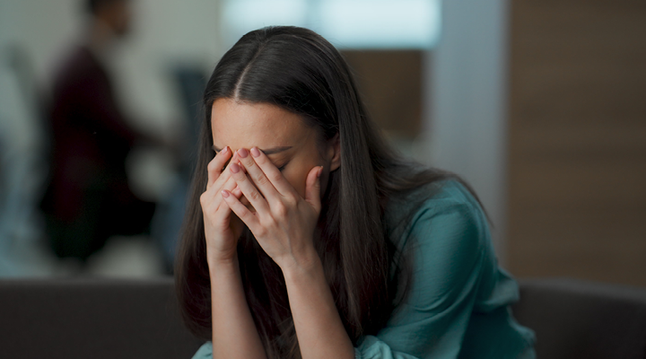Person putting their hands on their face, feeling stressed.
