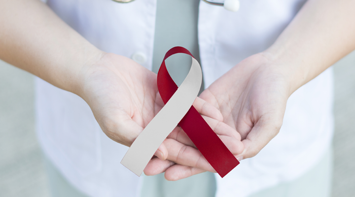 Person holding an Oral Cancer Awareness Ribbon.