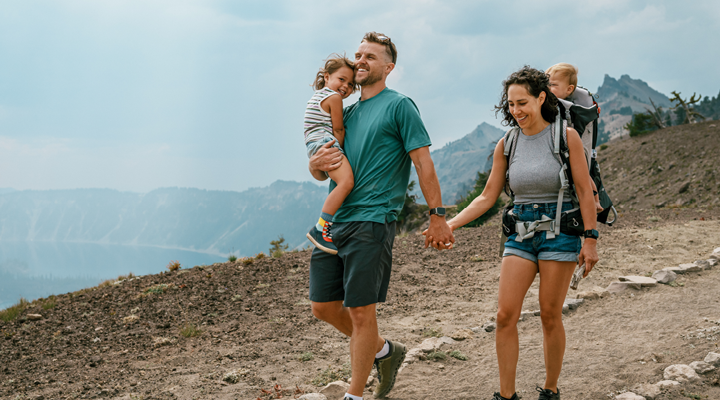 Family smiling and hiking in the mountains.