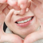 Person holding up a heart shape with their hands.