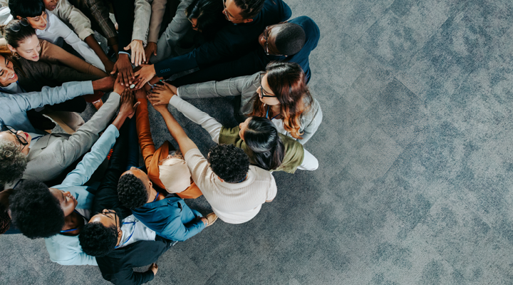 Coworkers in a group huddle.