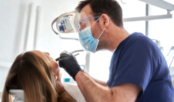 Dentist performing a oral health exam on a patient.