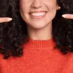 Person pointing at their smile.