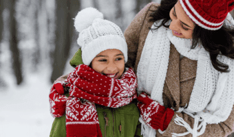 Mother and daughter smiling outside in the snow.