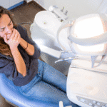 Person covering their mouth in the dental chair.