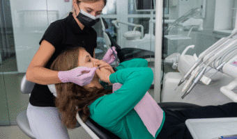 Person coving their mouth in the dental chair.